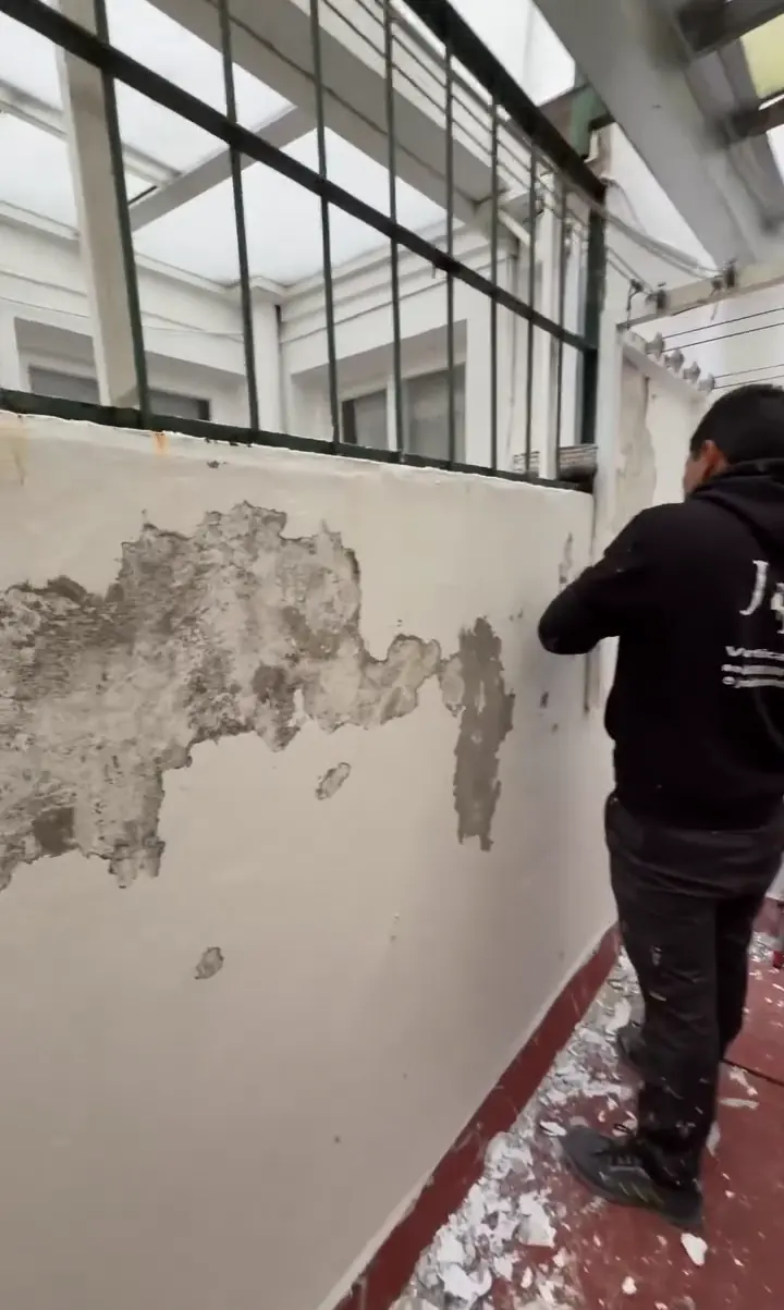 Antes: un operario de JMI picando la pared, con la pintura desconchada