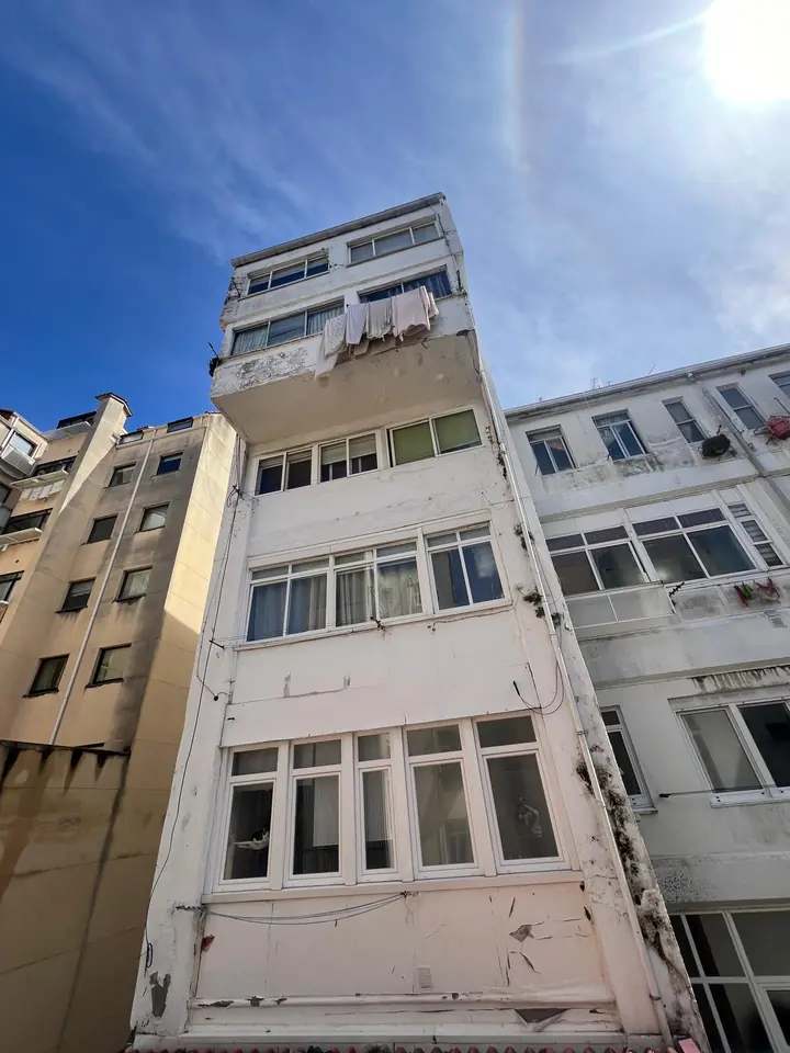 Antes: fachada con la pintura desconchada y manchas de humedad