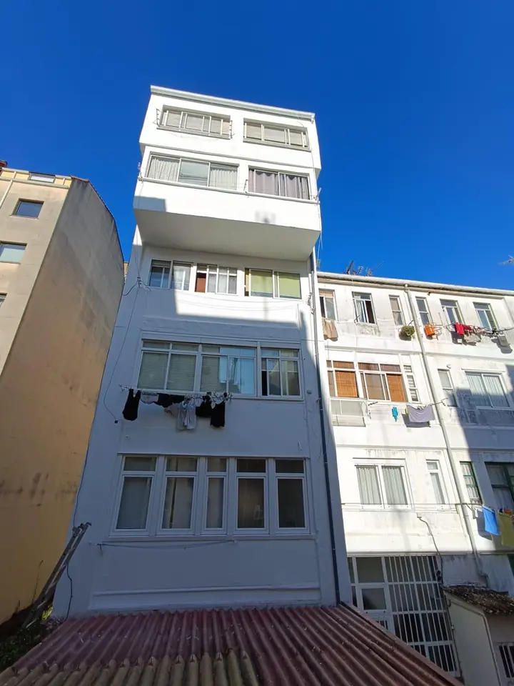 Después: la misma fachada reparada y pintada de blanco