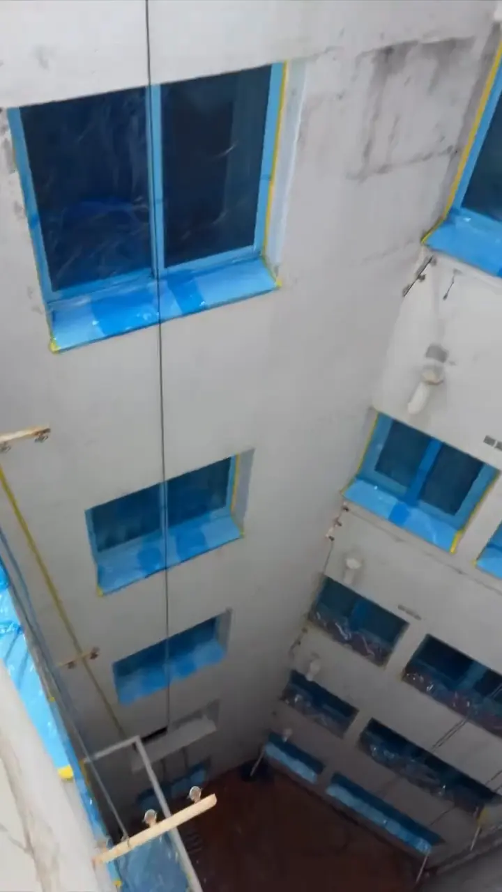 Patio de luces con las ventanas tapadas con plástico para protegerlas durante el trabajo